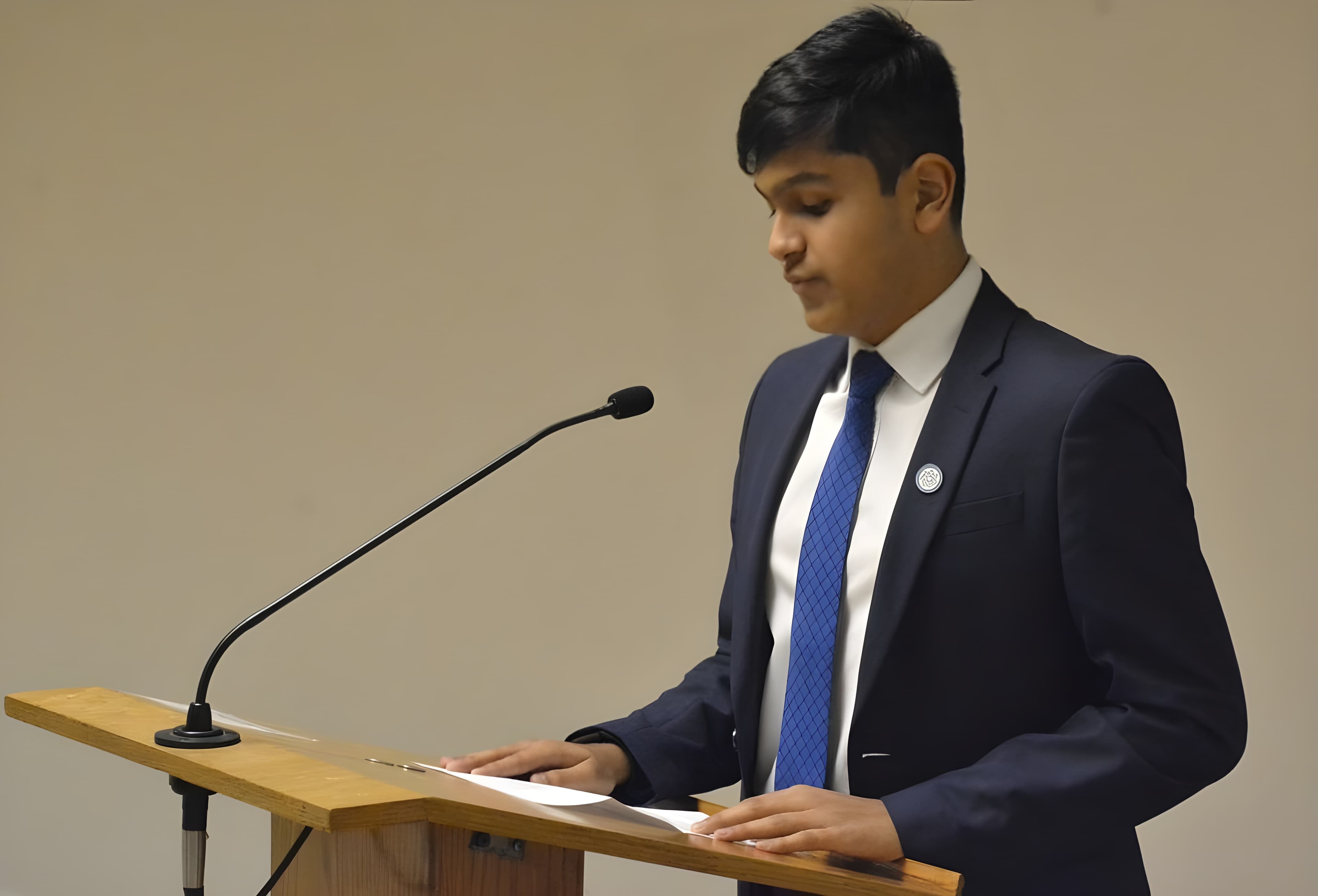 Adil Mukhi presenting at a lectern