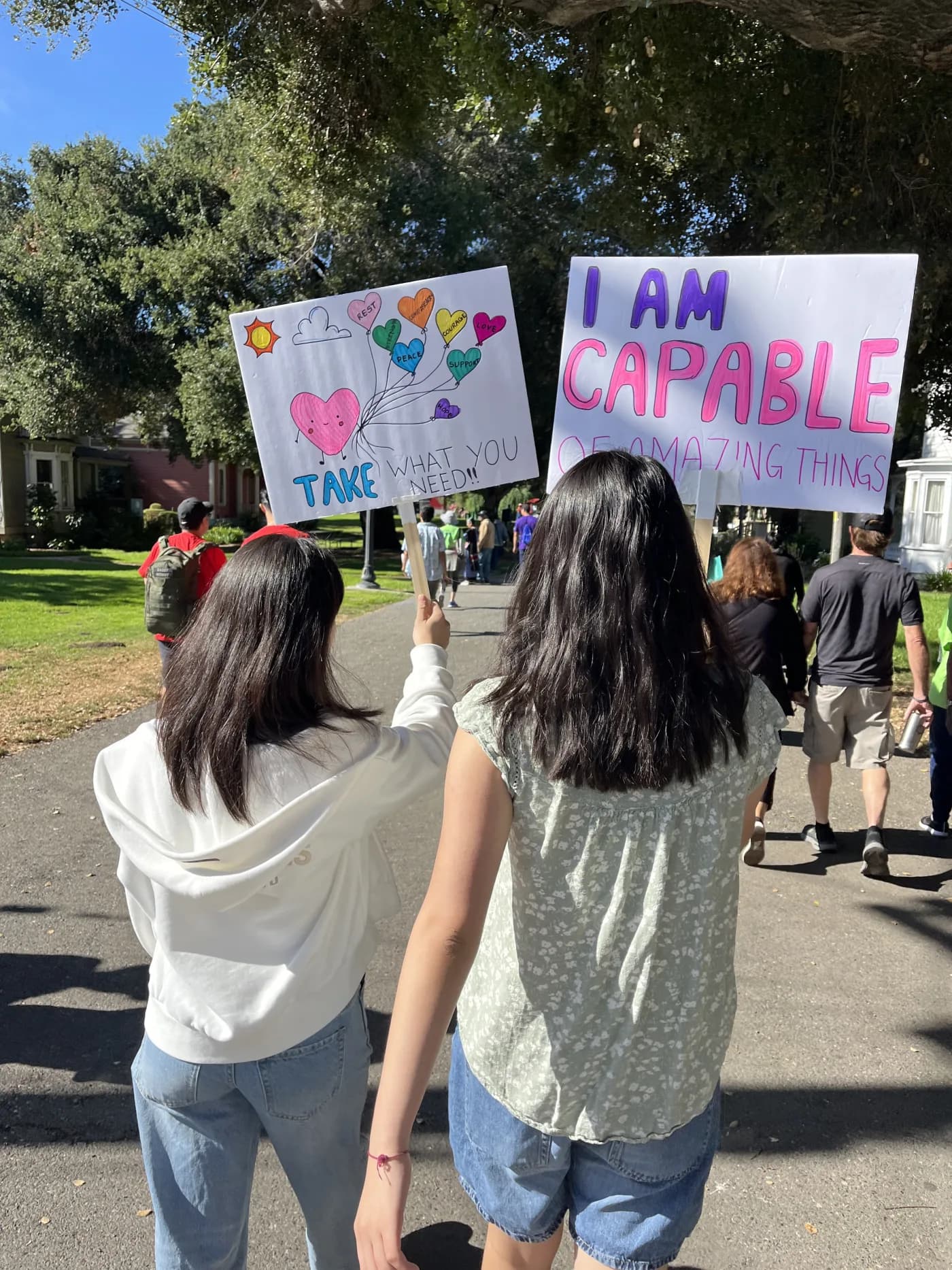 Students carrying supportive mental health messages at a community walk